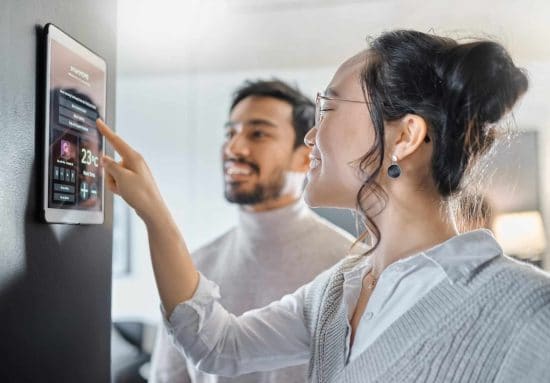 Un couple gérant leur maison connectée avec un moniteur